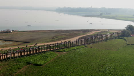 people walking over the u-bein bridge in mandalay in myanmar