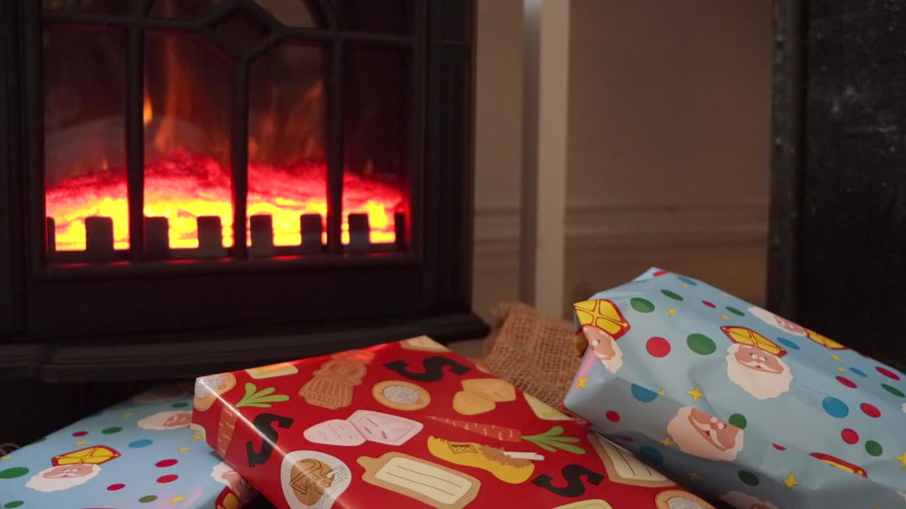 Colorful wrapped Sinterklaas holiday gifts in front of a fireplace