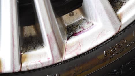 Timelapse-of-the-rim-of-the-wheel-being-cleaned-with-foamy-liquid-and-soap