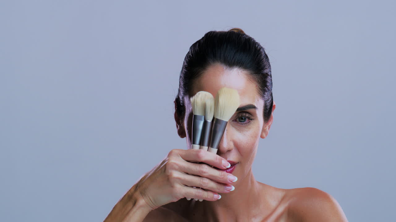 Donna che tiene pennelli per il trucco