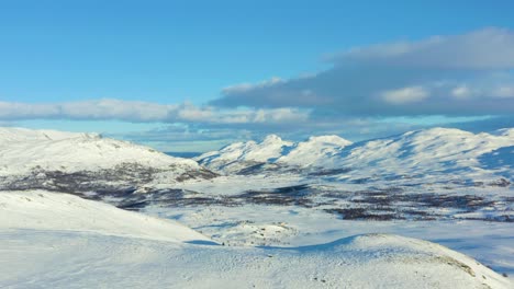 Aerial-over-the-snow-covered-valley-and-mountains-in-Hemsedal,-Norway