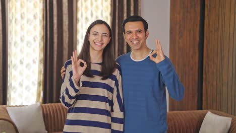 happy indian couple showing okay sign gesture