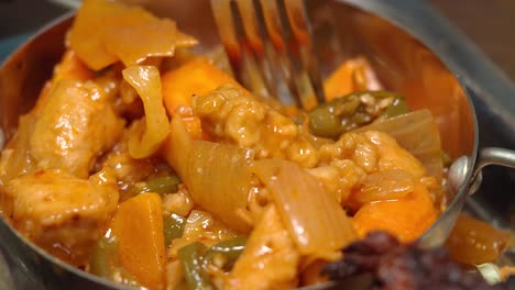 close-up of a delicious chicken and vegetable curry dish in a metal bowl
