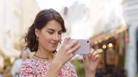 Blogger-Mujer-Caucásica-Usando-Un-Teléfono-Inteligente-Tomando-Fotografías-De-Edificios-Antiguos-De-La-Ciudad-Al-Aire-Libre