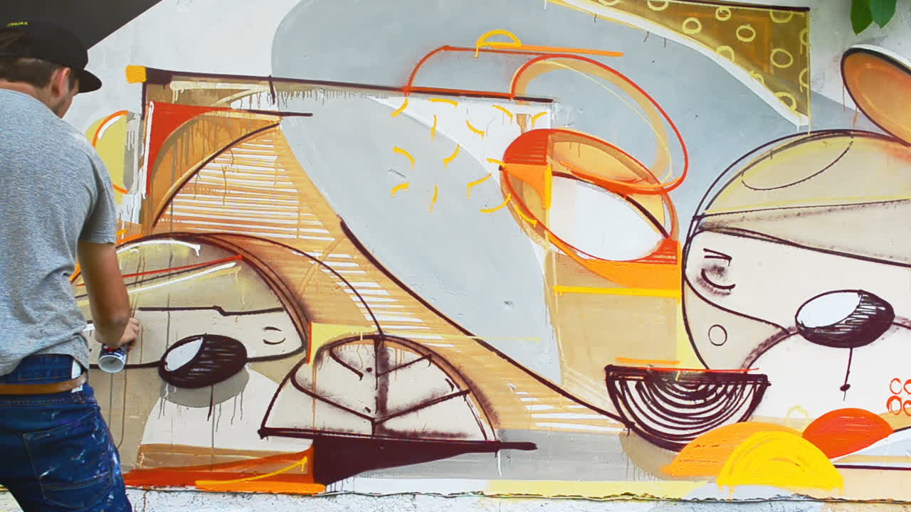 L'artista disegna graffiti su una recinzione. Graffiti su una recinzione.