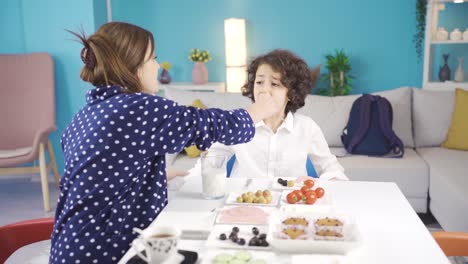 Cute-mom-and-son-are-having-breakfast-in-the-morning-and-mom-sends-her-son-to-school.