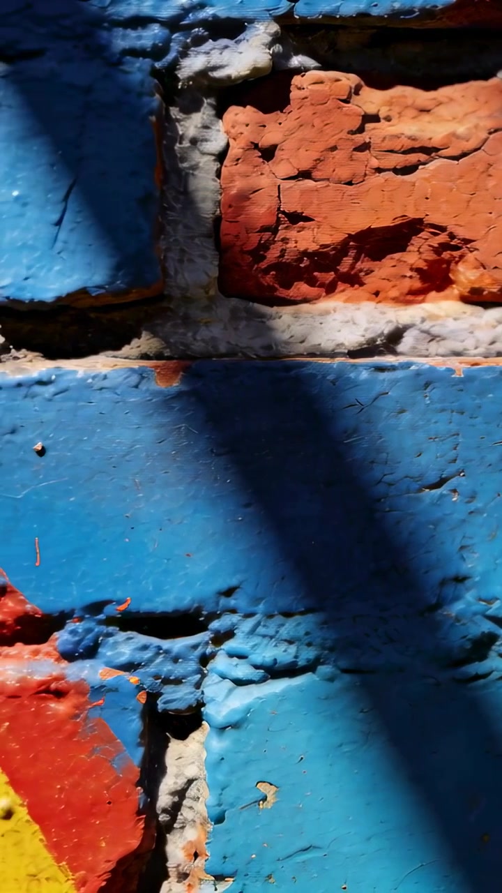 Video verticale: Telecamera scorrevole che parte dal primo fotogramma su un muro di mattoni, rivelando un dettaglio giallo.