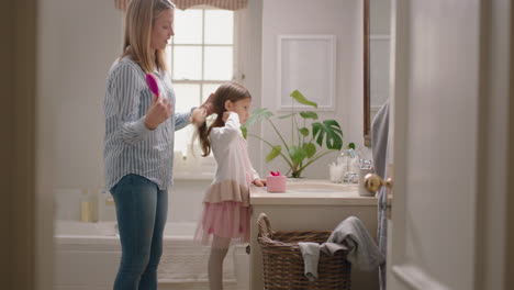 madre feliz cepillando el cabello de sus hijas en el baño niña linda preparándose por la mañana madre amorosa disfrutando de la paternidad cuidando del niño