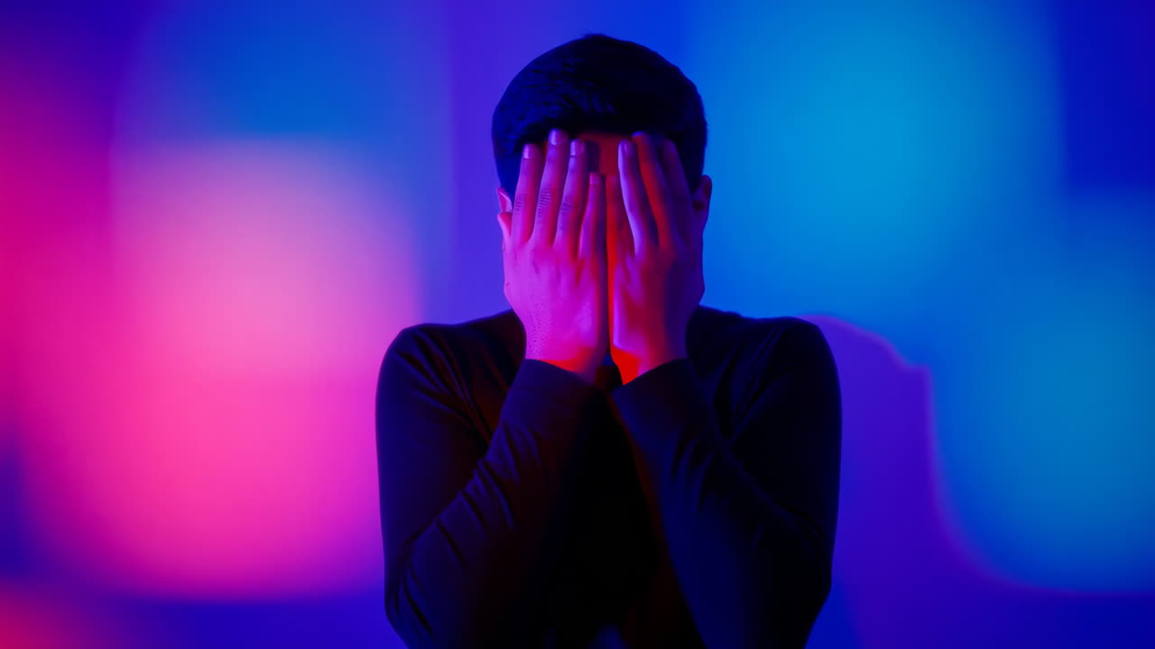 un hombre cubriendo su cara con las manos