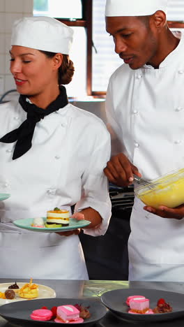 tres cocineros colocando platos de postre en el mostrador