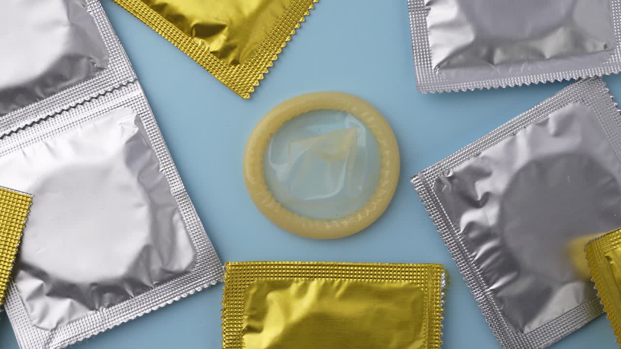 Exibindo pacotes de preservativos em um plano de fundo azul