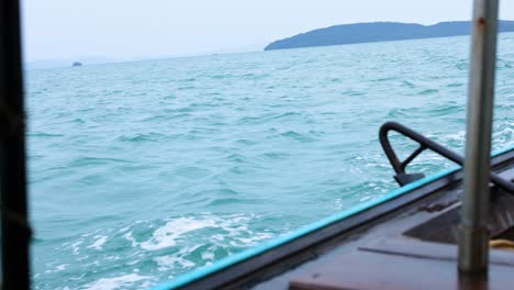 boat traveling through turquoise waters near islands in krabi, thailand