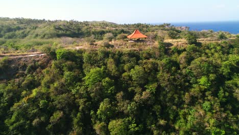 orange roof shed on top of tropical hills near atuh beach in nusa penida bali - aerial