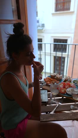 mujer disfrutando de una comida en un balcón