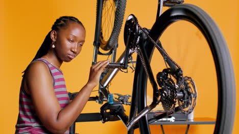 Woman-checking-bicycle-performance-by-spinning-bike-wheel