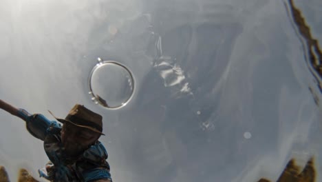 un hombre tomando un video de sí mismo con su cámara bajo el agua en paralia emplisi, grecia