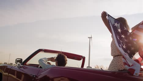 Video-Portátil-De-Una-Pareja-En-Un-Auto-Con-Bandera-Americana.