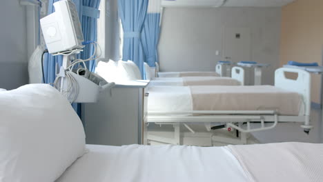 row of empty, freshly made beds and equipment in empty hospital ward, copy space, slow motion