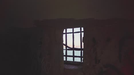 abandoned viewpoint with graffiti walls reveals river and big bridge through window with grids