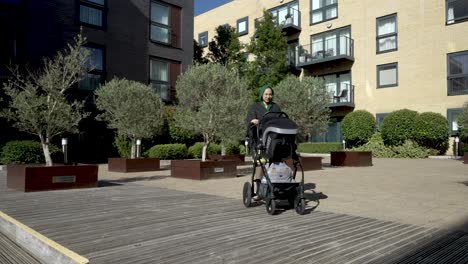 Young-Muslim-Mother-Pushing-Pram-In-Urban-Park