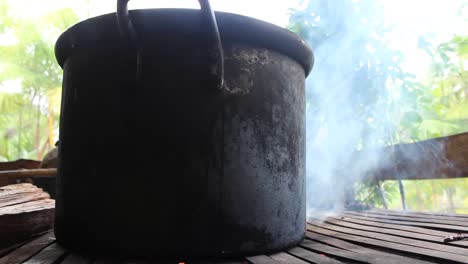 big black cooking pot on grill with smoke