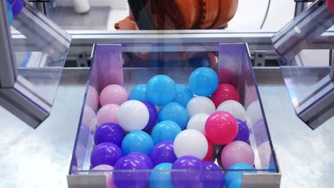el brazo del robot recogiendo y colocando bolas de colores