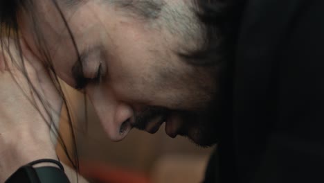 closeup of a young man in black suit praying in church in cinematic slow motion