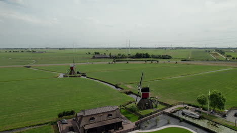 aerial view of old and historic doesmolen seesaw mills in the field with polders in hoogmade, netherlands