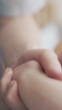 skilled pediatrician hands hold newborn boy little legs and practice hypertonus massage extreme close view