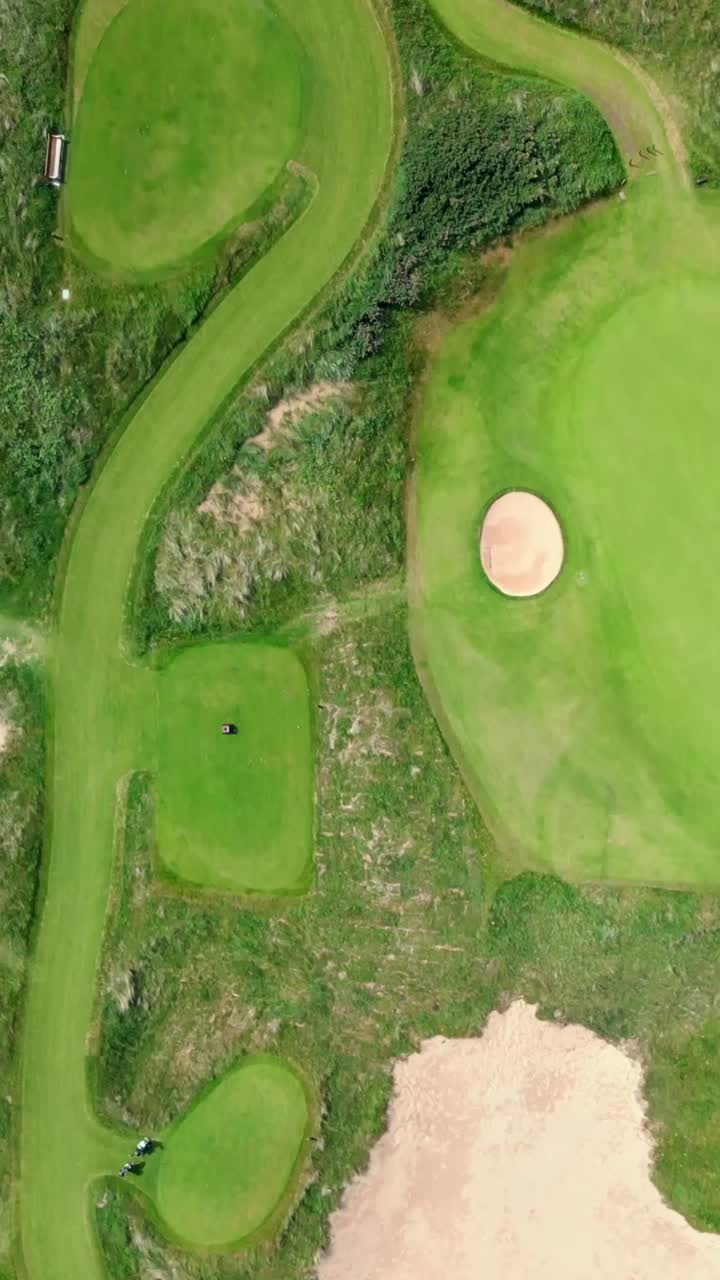 Top-down social ratio aerial video of Royal Portrush Golf Course in County Antrim, Northern Ireland, UK on a sunny day. Produced in 1080x1920 vertical ratio, 60FPS and with Rec709 color