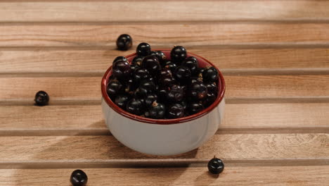 black currants in a bowl on wooden table