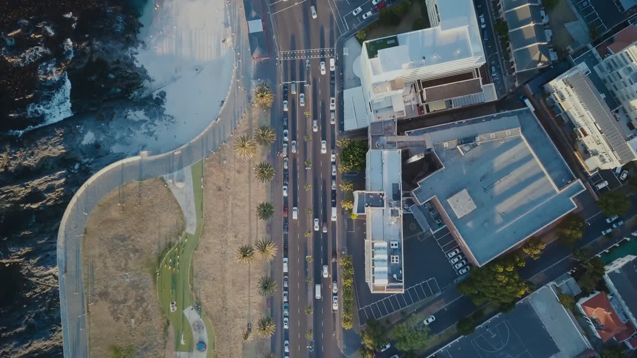 남아프리카 케이프타운에서 해가 지는 동안 도로에 있는 자동차를 따라 내려가는 드론 뷰