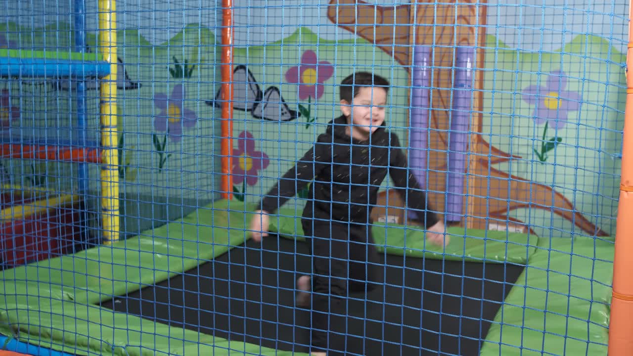 6-year-old boy jumping on the trampoline at the play center
