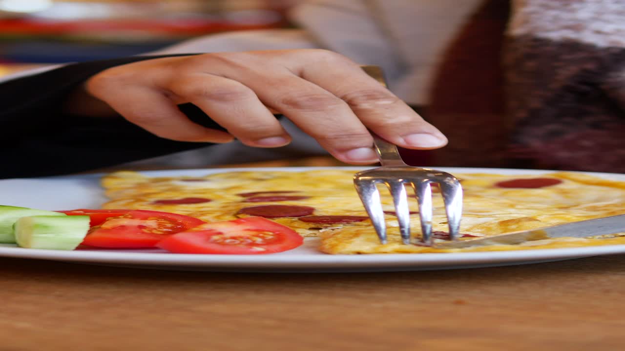 persona comiendo una tortilla de desayuno turca