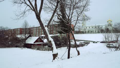 casas de madera, un edificio de apartamentos de la urss y una iglesia ortodoxa rusa en la nieve