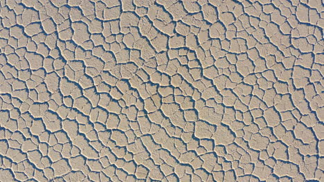 rising aerial over dry salt pans at badwater basin of death valley national park on bright sunny day