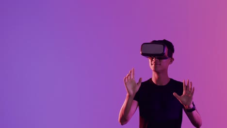 Asian-man-using-vr-headset,-touching-virtual-screen-on-purple-background,-copy-space,-slow-motion