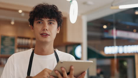 man using tablet in coffee shop