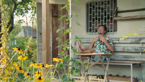 man relaxing on a porch in a garden
