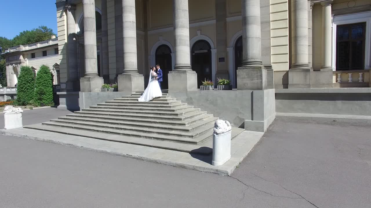 Wedding Day. Wedding Session. Aerial shot of a happy wedding couple hugs each other before old building
