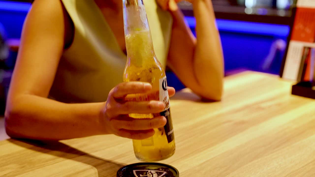 una mujer disfrutando de una cerveza en un bar.