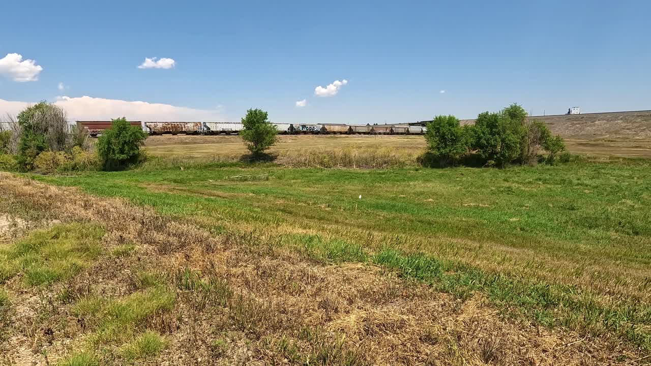 Two trains running in opposite directions carry cargo across Nebraska's prairie near Sidney Nebraska; concepts for freight and cargo transportation
