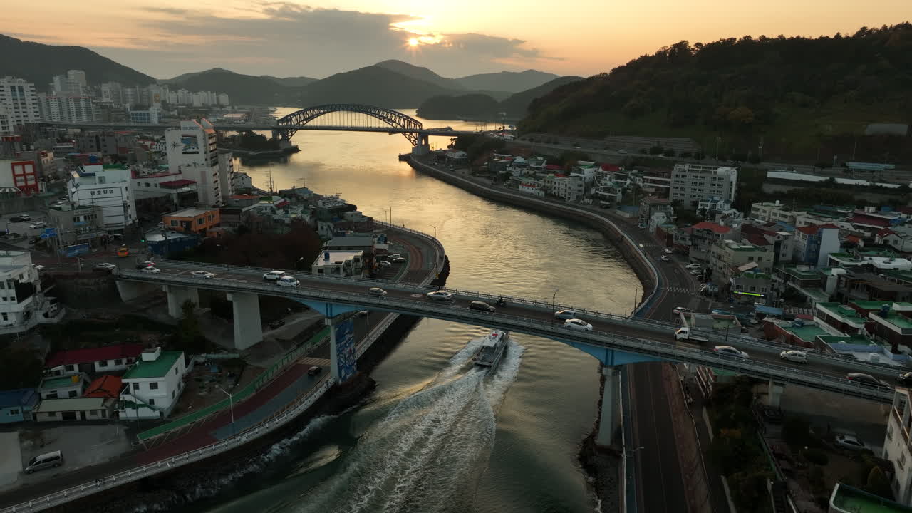vista aérea de un barco navegando hacia una puesta de sol en tongyeong, corea del sur, una ciudad costera ubicada en la provincia de gyeongsang