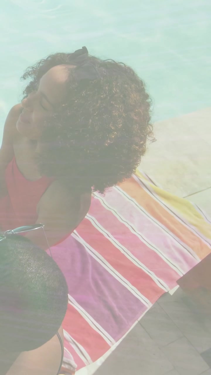 Vertical video: Woman turning head responding to friend, health tags appearing over towel, pool