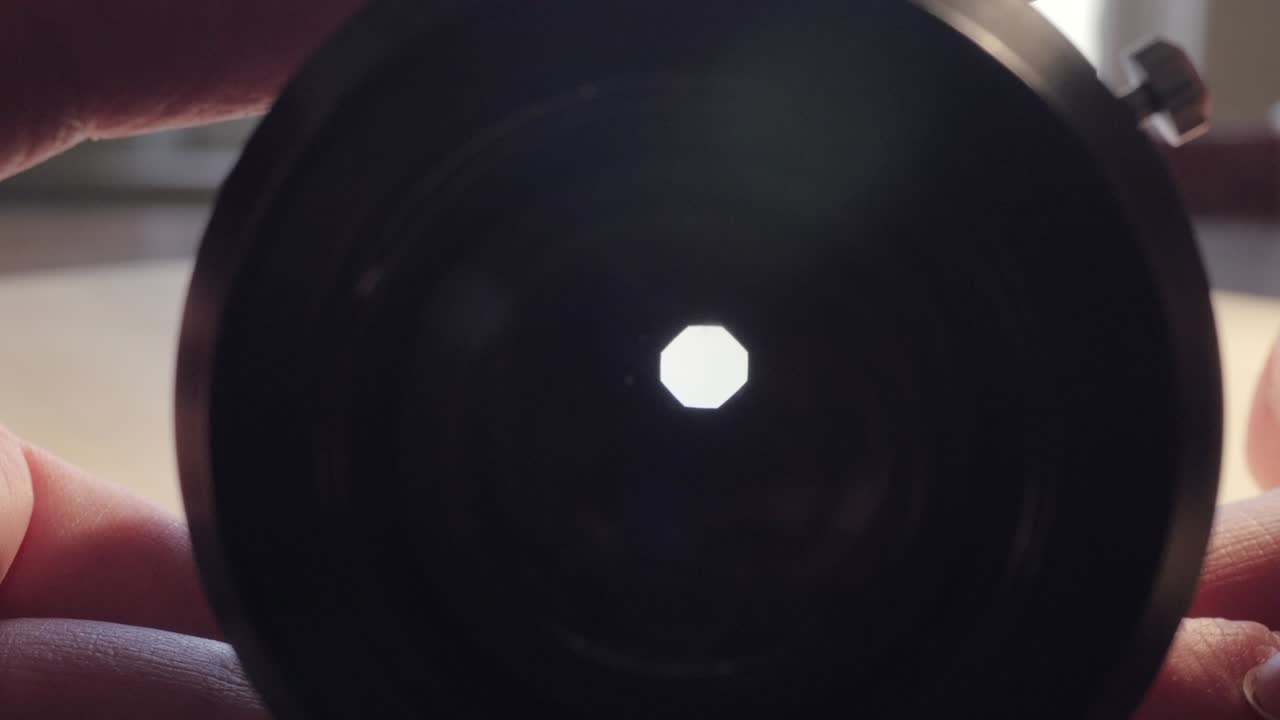 여성 사진작가는 사진 필름 렌즈의 창을 열고 닫습니다.