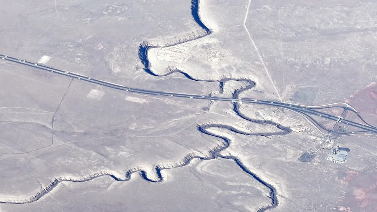 Aerial view capturing the Rio Grande Gorge Bridge and surrounding canyon from an airplane window showcasing scenic landscape and architecture