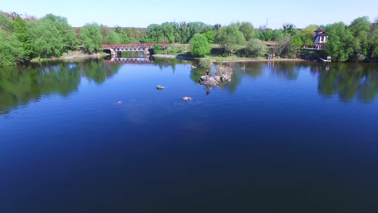 Cyclist looking throught river. Male tourist cyclist standing on shore of lake