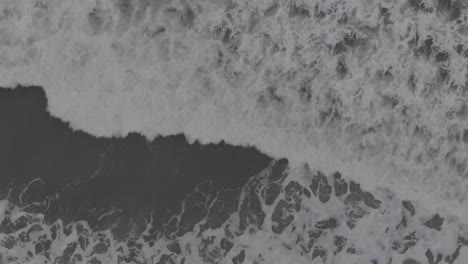 slow motion of foamy waves splashing in the sea - birdseye view, top-down