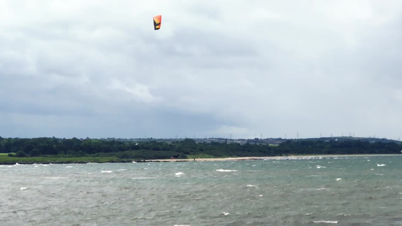 바람 부는 여름날 공중으로 20피트를 점프하고 멋지게 착지하는 카이트 서퍼 | 포토벨로 비치, 에딘버러 | 시네마틱 24fps로 hd로 촬영