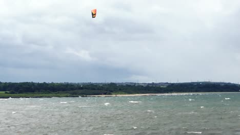 Un-Kitesurf-Saltando-20-Pies-En-El-Aire-Y-Aterrizando-Con-Estilo,-En-Un-Ventoso-Día-De-Verano-|-Playa-De-Portobello,-Edimburgo-|-Filmado-En-Hd-A-24-Fps-Cinemáticos